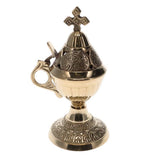 Decorative brass incense burner with a cross on a white background