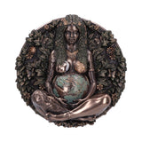 Bronze sculpture of a woman holding a fruit, surrounded by foliage on a white background