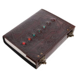 Decorative leather journal with embossed patterns and colored stones on a white background