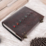 Decorative leather journal with embedded colorful stones on a textured surface