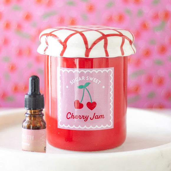 Jar of cherry jam with a dropper bottle on a pink background