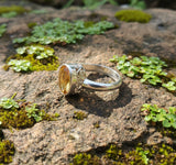 Silver ring with intricate design on a light gray background