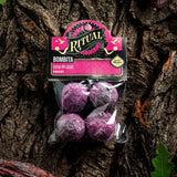 Packaged purple bath bombs with 'Ritual' branding on a tree bark background