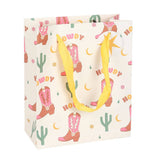 Gift bag with cowboy boot and cactus pattern on a white background