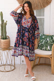 Woman wearing a colorful patterned dress in a tropical setting with a cactus and palm leaves.
