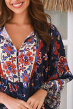 Woman wearing a colorful floral patterned blouse with a blurred background