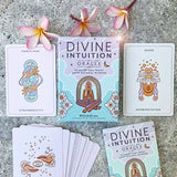 Divine Intuition Oracle cards on a concrete surface with flowers.