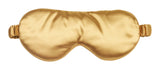 Gold satin sleep mask on a white background