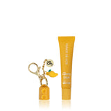 Yellow lip balm tube and keychain on a white background