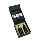 Two black bottles in an open black box on a white background