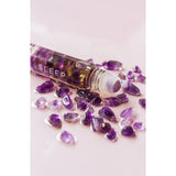 Roll-on bottle labeled 'SLEEP' with purple crystals on a light pink background