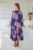 Woman wearing a floral dress on a wooden deck