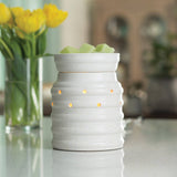 White ceramic diffuser on a table with yellow tulips in the background
