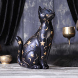 Decorative black cat figurine with gold stars and moons on a dark background