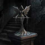 Statue of an angel with a sword on a dark background
