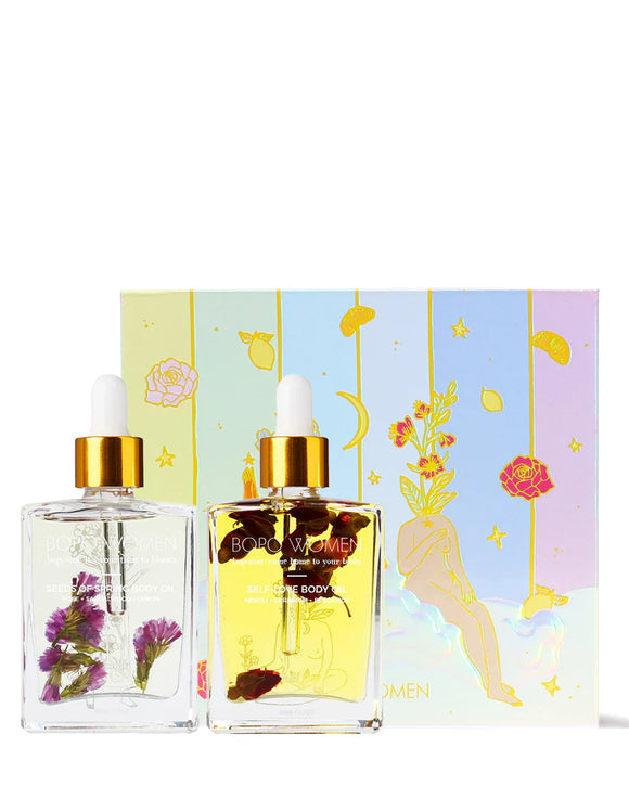 Two perfume bottles with floral elements and a decorative box on a white background