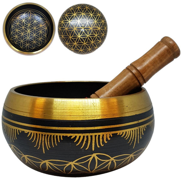 Decorative black and gold singing bowl with wooden handle on a white background