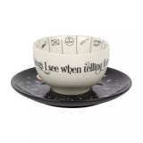 Ceramic bowl with text and symbols on a matching saucer against a white background