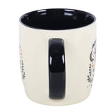 White mug with black interior and handle, featuring decorative elements on a white background