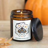 Spiced vanilla scented candle in an amber jar with a decorative label on a wooden surface.