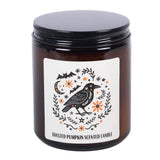 Candle jar with a decorative label featuring a crow and autumn elements on a white background.