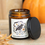 Toasted pumpkin scented candle with decorative label on a wooden surface