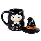 Black mug with a witch design and matching witch hat on a white background
