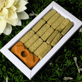 Box of pet treats with a bone-shaped treat on a grassy background