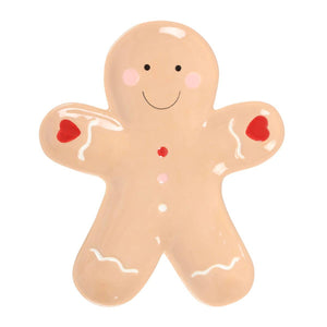 Gingerbread man-shaped cookie with red buttons on a white background