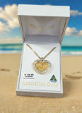 Gold heart pendant necklace in a 'Goulds' box on a wooden surface