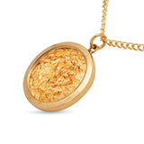 Gold necklace with a round pendant on a white background