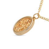 Gold necklace with a textured pendant on a white background