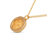 Gold necklace with a round pendant on a white background