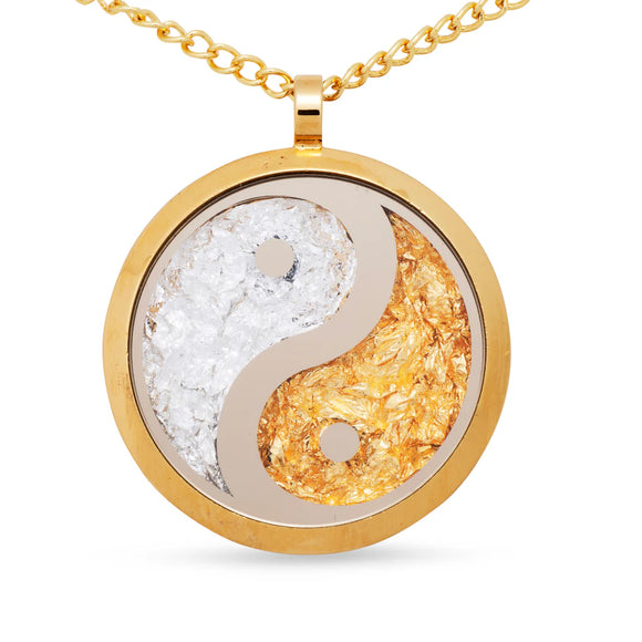 Yin and yang symbol pendant on a gold chain against a white background