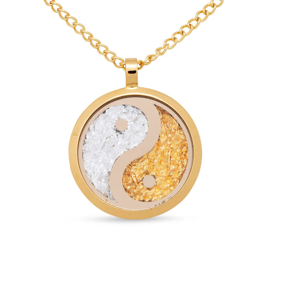 Gold necklace with a yin yang pendant on a white background