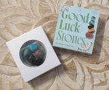 Box of 'Good Luck Stones' on a textured surface
