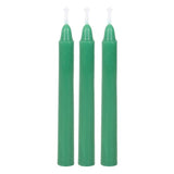 Three green candles with white wicks on a white background