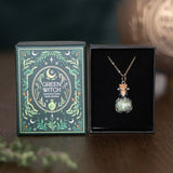 Green Witch necklace in a bottle with packaging on a dark background