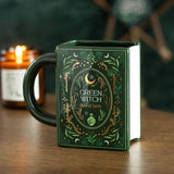 Green witch-themed mug with decorative design on a wooden surface next to a candle.