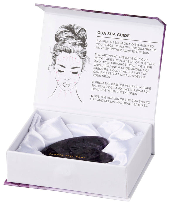 Gua sha tool in a white box with instructions on a white background