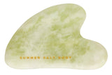 Green gua sha tool with 'Summer Salt Body' branding on a white background