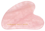 Pink gua sha tool with 'Summer Salt Body' text on a white background
