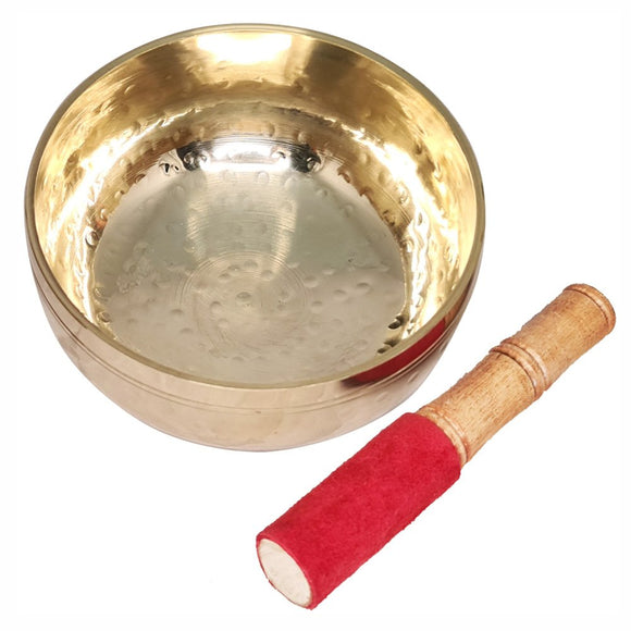 Brass singing bowl with wooden and red-felt striker on a white background
