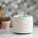 White textured diffuser with colorful stones on a marble surface and hexagonal tile wall background