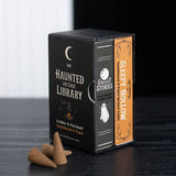 Two incense cone packages from 'The Haunted Incense Library' on a dark surface.
