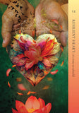 A book or magazine cover featuring two hands cupping a colorful lotus flower on a leaf, with the title 'RESILIENT HEART: it's time to rebuild' and the number 12 on a vertical peach-to-orange band along the right side.