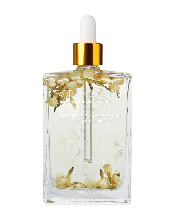 Clear bottle with floral design and gold cap on a white background