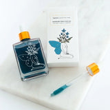 Bottle of Hormone Hero Face Oil with packaging on a white surface