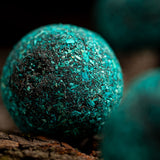 Close-up of a textured teal sphere on a dark background