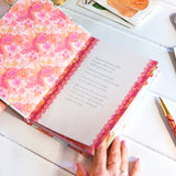 Open book with floral pages on a light surface